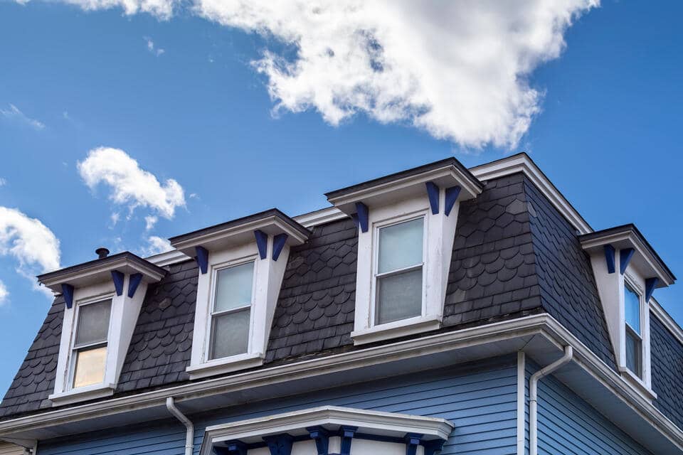 pitched roof-mansard roof on a blue sided house