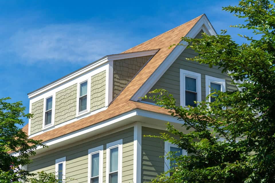 types of dormers-green sided house with light brown shingle roof and dormers
