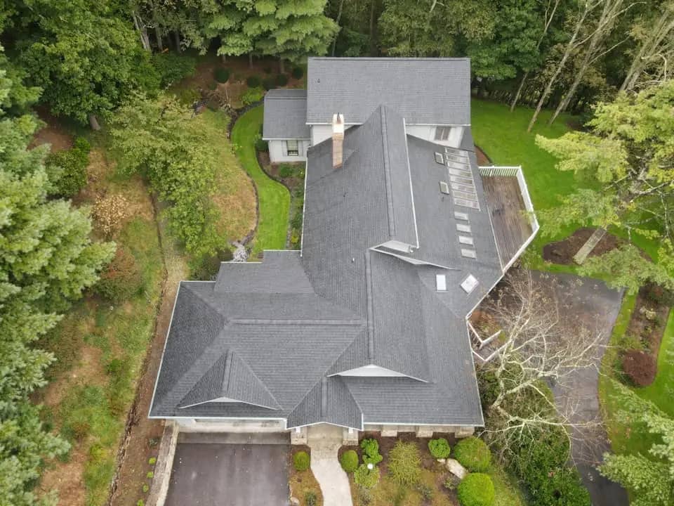 drone view of a new asphalt shingle roof in a green forest