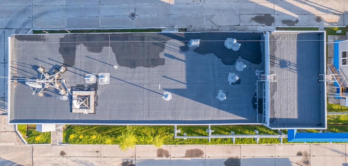Aerial view of a flat industrial building roof with water damage
