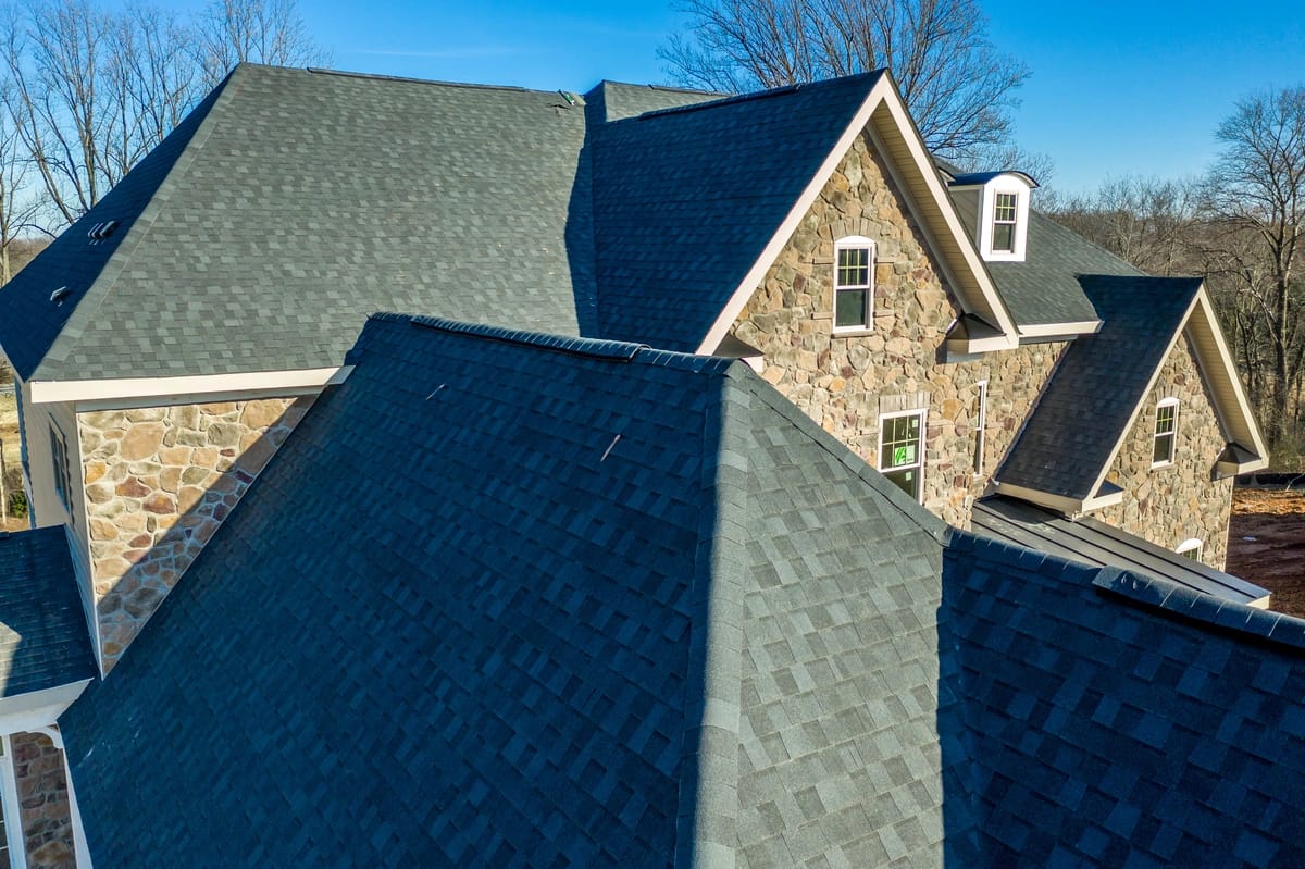 green asphalt shingle roof of the large house