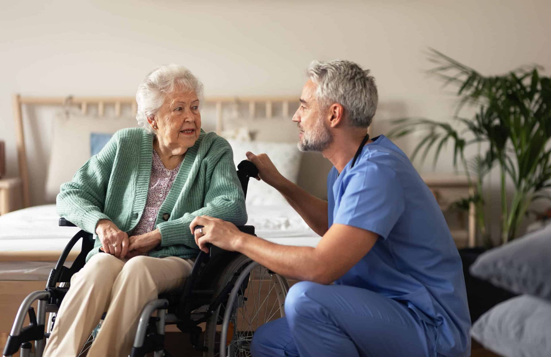 nurse talking with woman in wheelchair